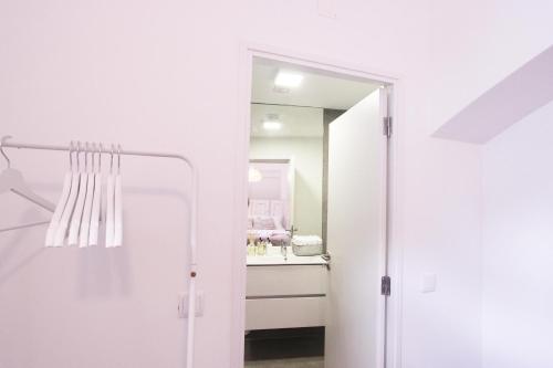 a white bathroom with a sink and a mirror at Lavradores Boutique Guesthouse in Évora