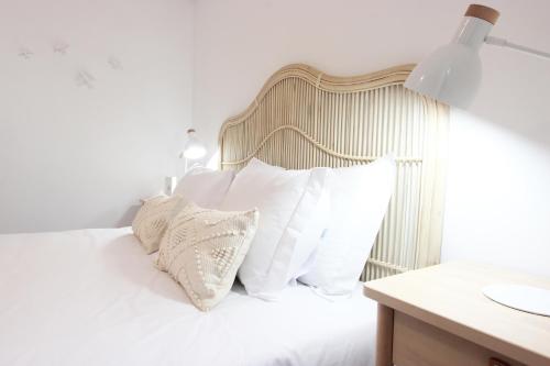 a bedroom with a white bed with white pillows at Lavradores Boutique Guesthouse in Évora