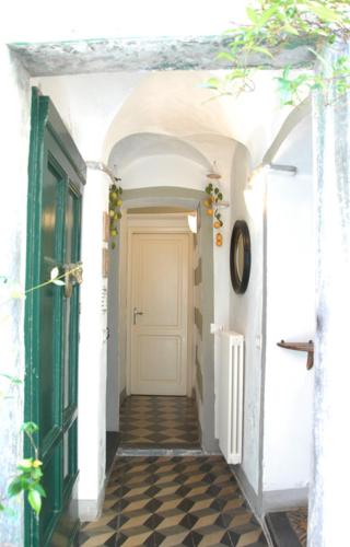 a hallway with a white door and a checkered floor at Fivestay Roof terrace overlooking the gulf in Monte Marcello
