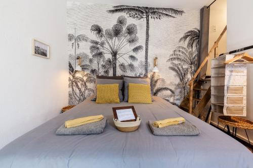 a bedroom with a bed with yellow and gray pillows at LE PANIER ENCHANTÉ - Suites & Loft - Terrasse et patio au dessus du Vieux Port in Marseille