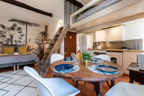 une cuisine et une salle à manger avec une table et des chaises en bois dans l'établissement LE PANIER ENCHANTÉ - Suites & Loft - Terrasse et patio au dessus du Vieux Port, à Marseille