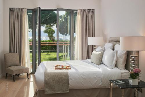 - une chambre avec un lit blanc et une grande fenêtre dans l'établissement FRGK"Contemporary Villa on the Croisette with Stunning Sea Views & Private Pool!!!, à Cannes