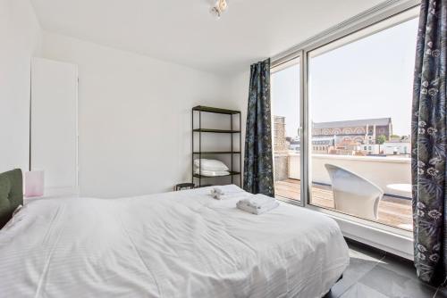 a bedroom with a white bed and a large window at Classy Apartment in City Center with Large Balcony in Ghent