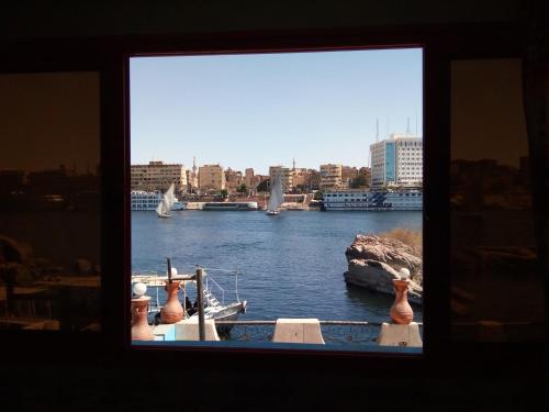 a boat in a body of water with a city at El-amin Guest House in Aswan