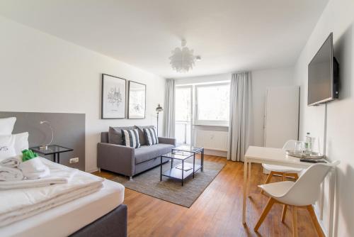 una sala de estar con una cama y un sofá en StayS Apartments, en Núremberg