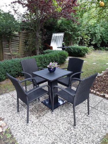 a black table and chairs with a bowl of flowers on it at Hotel kleine Auszeit - Adults Only in Sankt Peter-Ording