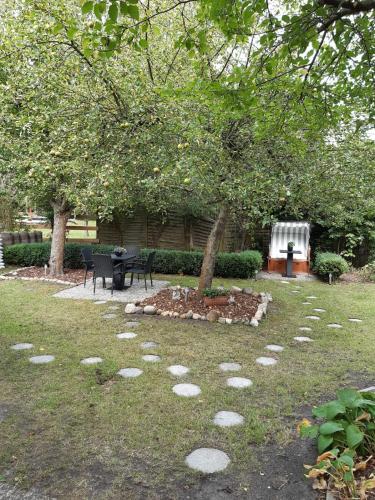 a tree in the middle of a yard withestones in the grass at Hotel kleine Auszeit - Adults Only in Sankt Peter-Ording