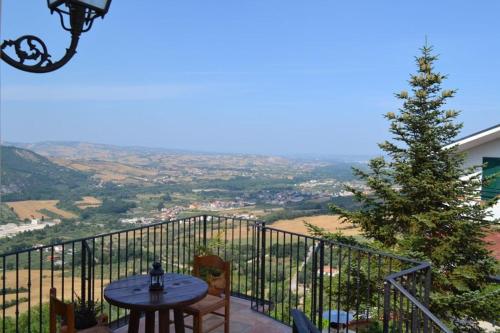 a table and chairs on a balcony with a christmas tree at Giardinotto Casa vacanze in Altino