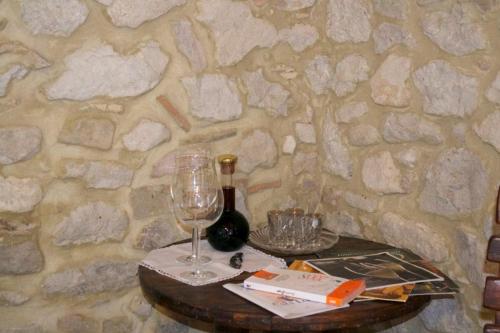 a table with a wine glass and a bottle of wine at Giardinotto Casa vacanze in Altino