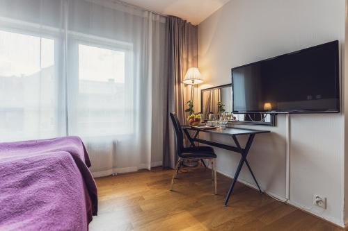 a hotel room with a desk with a television on a wall at Best Western Hotel Varnamo in Värnamo
