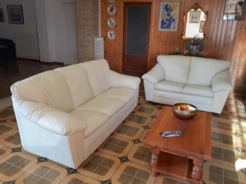 ein Wohnzimmer mit 2 weißen Sofas und einem Couchtisch in der Unterkunft Belvilla by OYO Casa Miralago in Magione