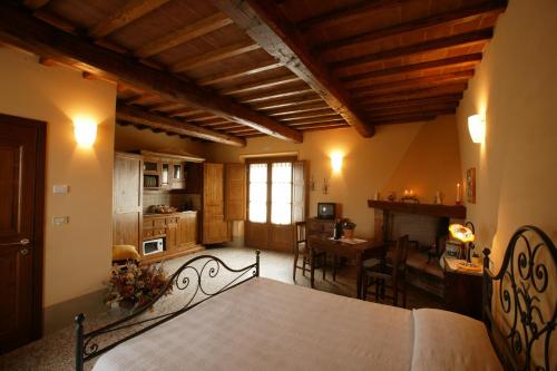 sypialnia z łóżkiem, kuchnia i stół w obiekcie Agriturismo Podere San Gregorio w mieście Pienza