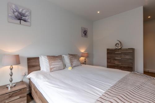 een slaapkamer met een groot wit bed en 2 lampen bij Luxury Central London Apartment in Londen