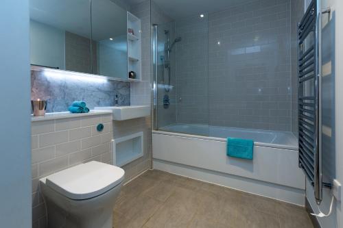 a bathroom with a toilet and a tub and a sink at Luxury Central London Apartment in London