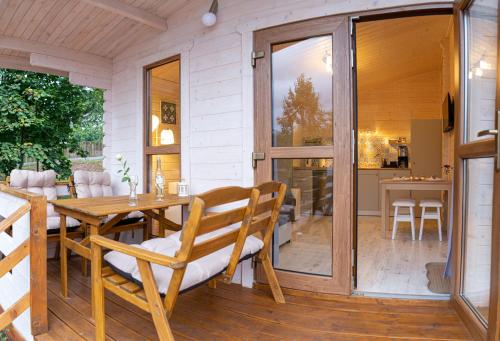 a porch with a wooden table and chairs on a patio at Sielankownia in Wünschelburg