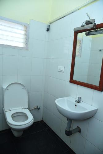 a bathroom with a toilet and a sink at Hotel Subhalakshmi Palace in Kāraikkudi