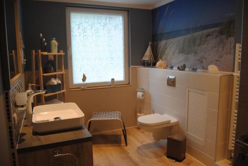 a bathroom with a sink and a toilet and a window at Ferienwohnung Bacharach-Steeger Tal in Bacharach