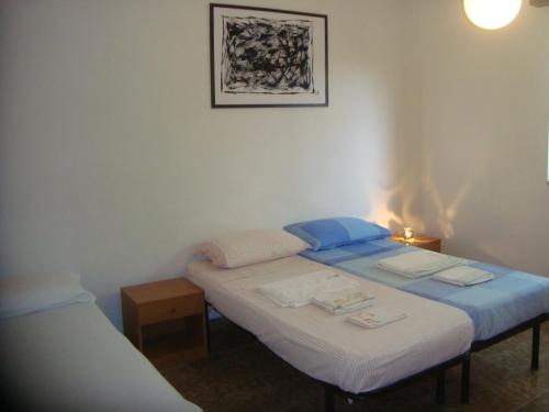 two twin beds in a room with a lamp at Villa degli Angeli in Santa Maria Del Focallo