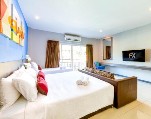 Ένα ή περισσότερα κρεβάτια σε δωμάτιο στο FX Hotel Pattaya