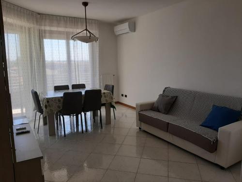 a living room with a table and a couch at DOMUS MARIS Viserba, Speciale offerta di Pasqua,Spiagge e Centro a 100 mt, a 5 minuti RIMINIFIERA Offerta THE COACH EXPERIENCE GINNASTICA IN FESTA RIMINI 2024 in Rimini
