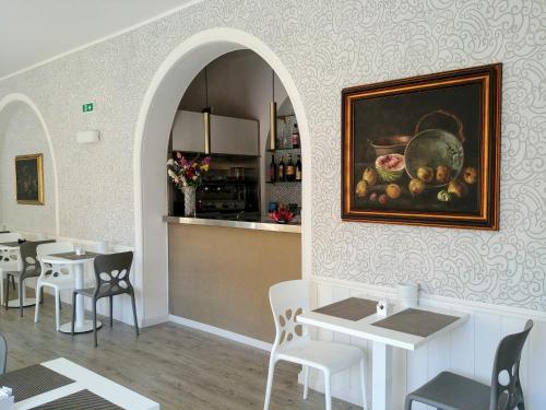 a restaurant with tables and a painting on the wall at Hotel Vittoria in Genova
