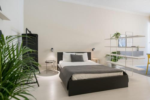 a bedroom with a bed and some plants at Baixa24 •P1L• Amplo estúdio na baixa com varanda in Porto