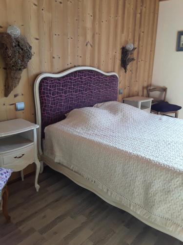 a bedroom with a bed and a wooden wall at Gîte in Montagny-sur-Grosne