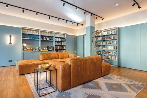 a living room with a brown couch and bookshelves at Velotel Bad Saarow in Bad Saarow