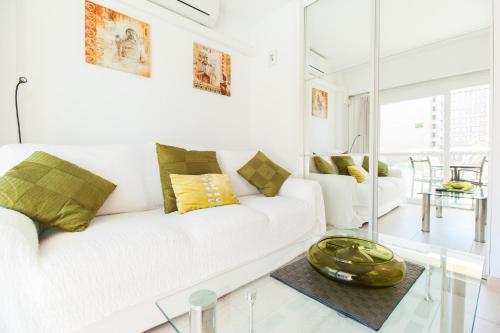 a white living room with a white couch and a glass table at PYR Private Apartment SUNNY pool SIDE in Fuengirola