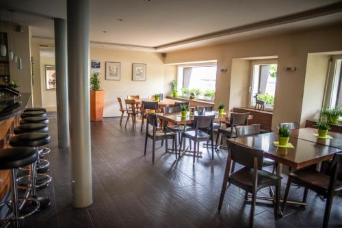 a restaurant with wooden tables and chairs and windows at Hotel Schützenhaus in Uznach