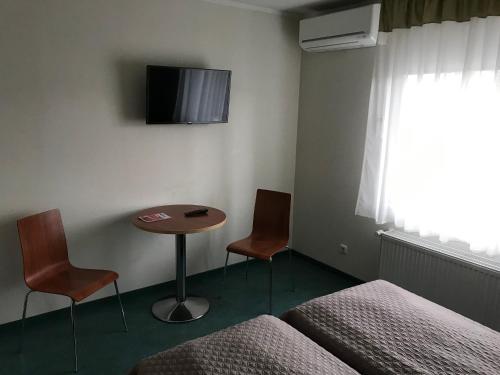 a room with a bed and a table and two chairs at Hommiku Guesthouse in Pärnu