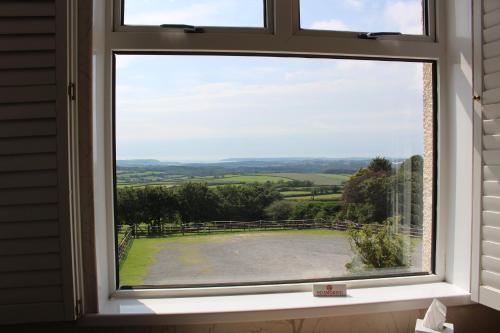 a window with a view of the countryside seen through it at The Moorland Hotel in Wotter
