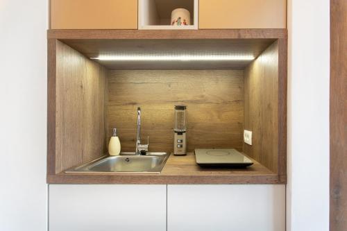 una cocina con fregadero en un armario de madera en NEW, Stylish and modern central Studio, FREE parking, en Celje
