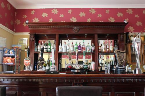 a bar in a pub with a lot of alcohol at The Moorland Hotel in Wotter