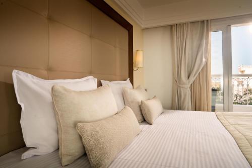 a bedroom with a bed with white pillows and a window at Sousse Palace Hotel & Spa in Sousse