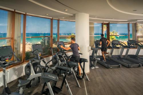 two men exercising in a gym with a view of the ocean at Sousse Palace Hotel & Spa in Sousse