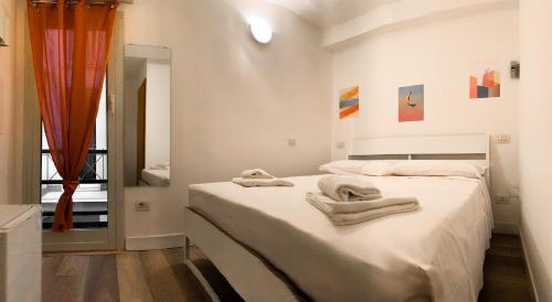 a white bedroom with two towels on a bed at Pied a Terre Barberini in Rome