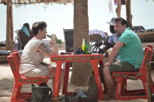Sanyang的住宿－Rainbow beach resort，坐在海滩桌子上的两个人