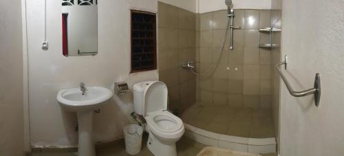 een badkamer met een toilet, een douche en een wastafel bij Tropical Paradise Nosy Be in Nosy Be