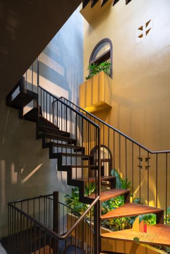 a spiral staircase in a building with plants at Deja Vu House Ha Long in Ha Long