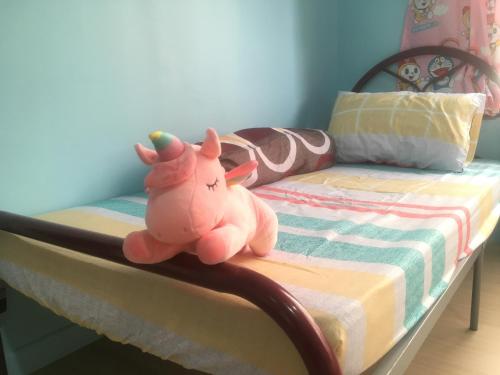 a stuffed animal is sitting on a bed at Woodsbury Suites 7722 Butterworth Penang in Butterworth
