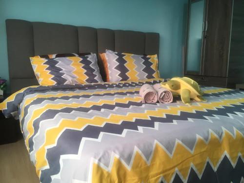 a bed with a stuffed animal and some pillows at Woodsbury Suites 7722 Butterworth Penang in Butterworth
