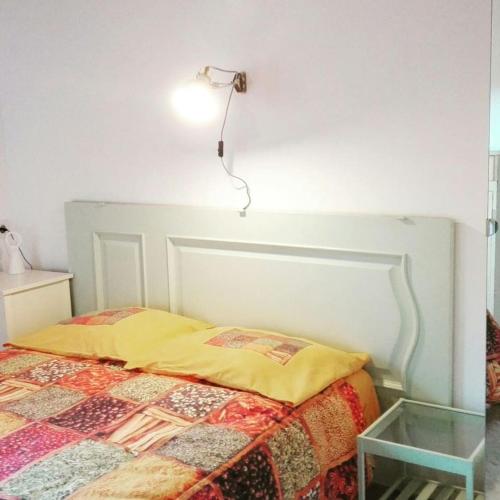 a bedroom with a bed with a lamp on the wall at Casalacapillajelgueres in Cangas de Onís