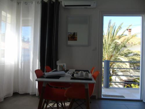 d'une salle à manger avec une table, des chaises et une fenêtre. dans l'établissement Vllla Reva, à Argelès-sur-Mer