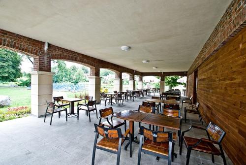 a patio with tables and chairs and a brick wall at Dom Pracy Twórczej in Uniejow