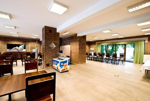a large room with tables and chairs and a dining room at Dom Pracy Twórczej in Uniejow