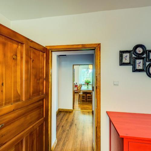 a hallway with a door leading to a dining room at Leśne Apartamenty in Zieleniec