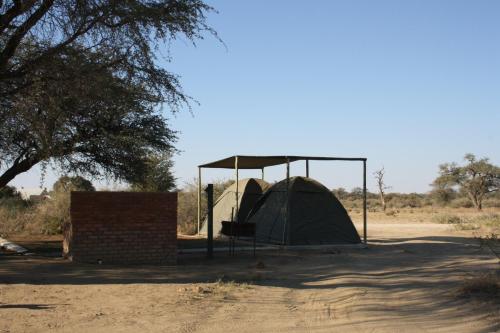 a tent in the middle of a field at Out Of Nature Country Lodge in Windhoek