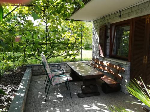 a picnic table and a chair outside of a house at Apartment Ajdna in Žirovnica