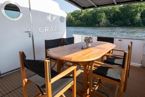 a wooden table and chairs on the back of a boat at GRACE Suite mit zwei Schlafzimmern in Berlin